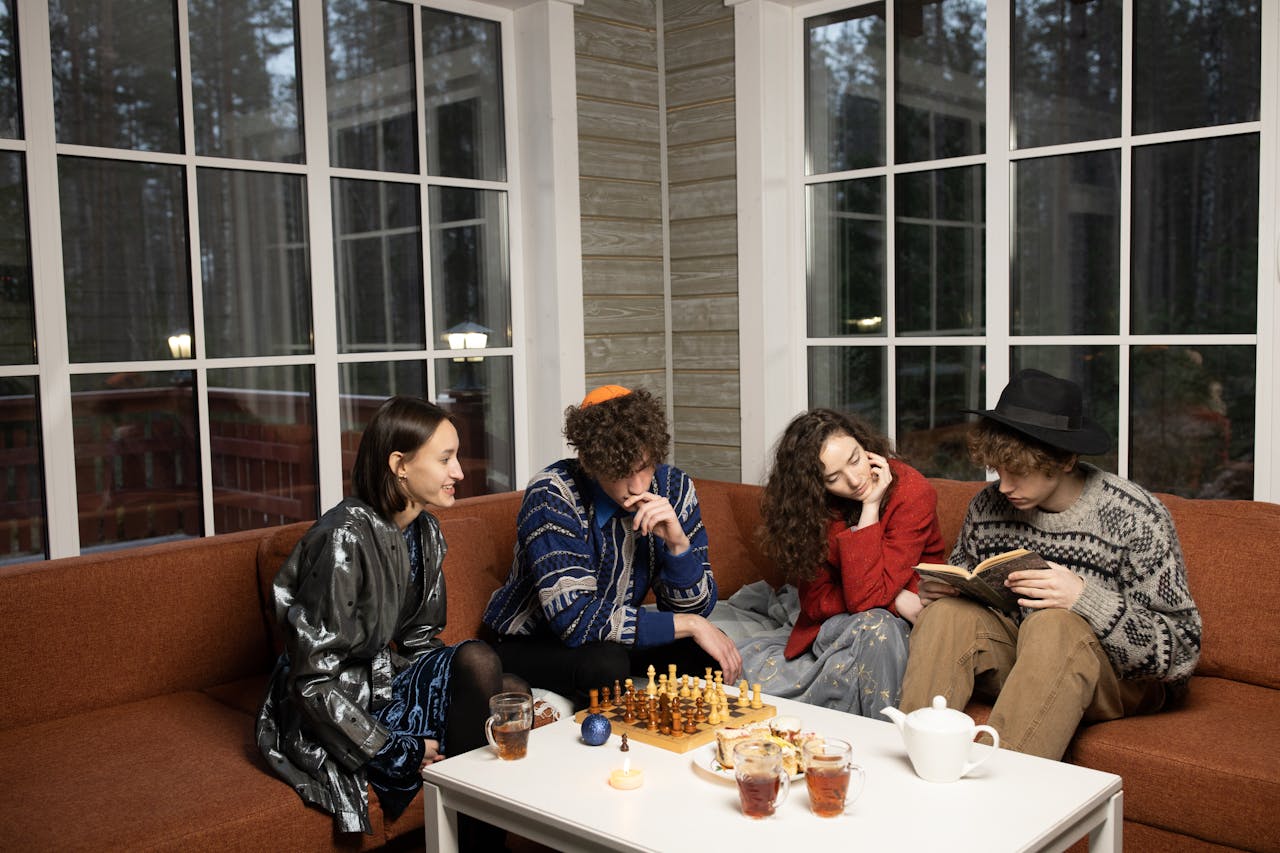 A group of young friends celebrating Hanukkah indoors with games and drinks, sharing a moment of togetherness.